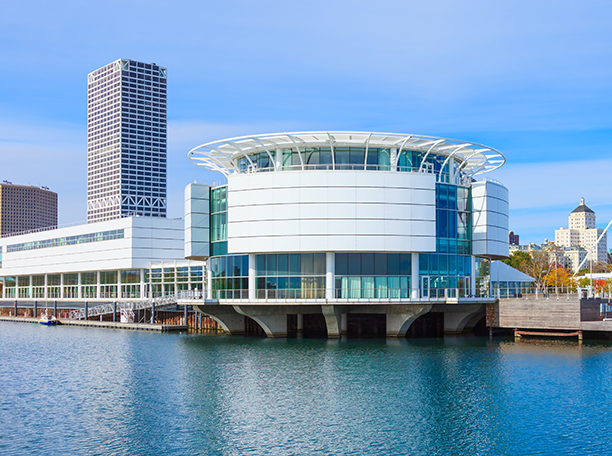 Discovery World’s circular building on Milwaukee’s lakefront with SilverPeak Strategic Capital office building rising in the background.
