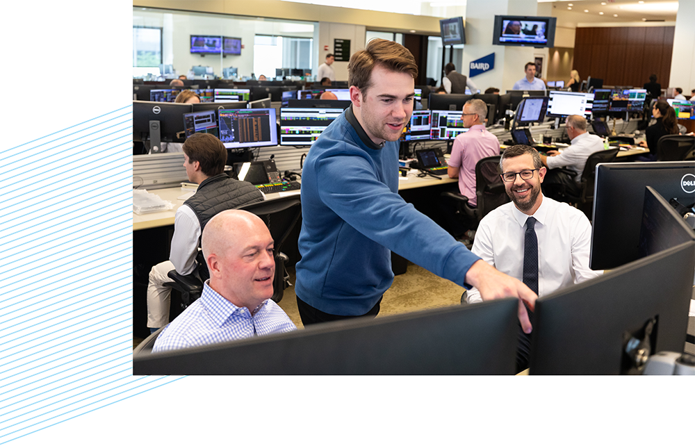 Three SilverPeak Strategic Capital associates looking at computer monitors on the trading floor